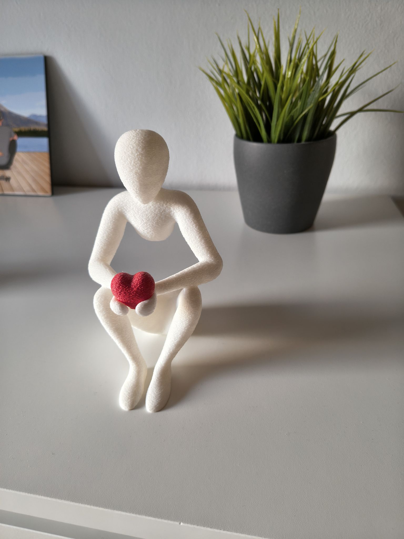 Weiße Figur mit einem roten Herz